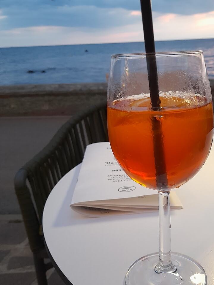 Aperol Spritz na stolu u plavi sat, iza njega more